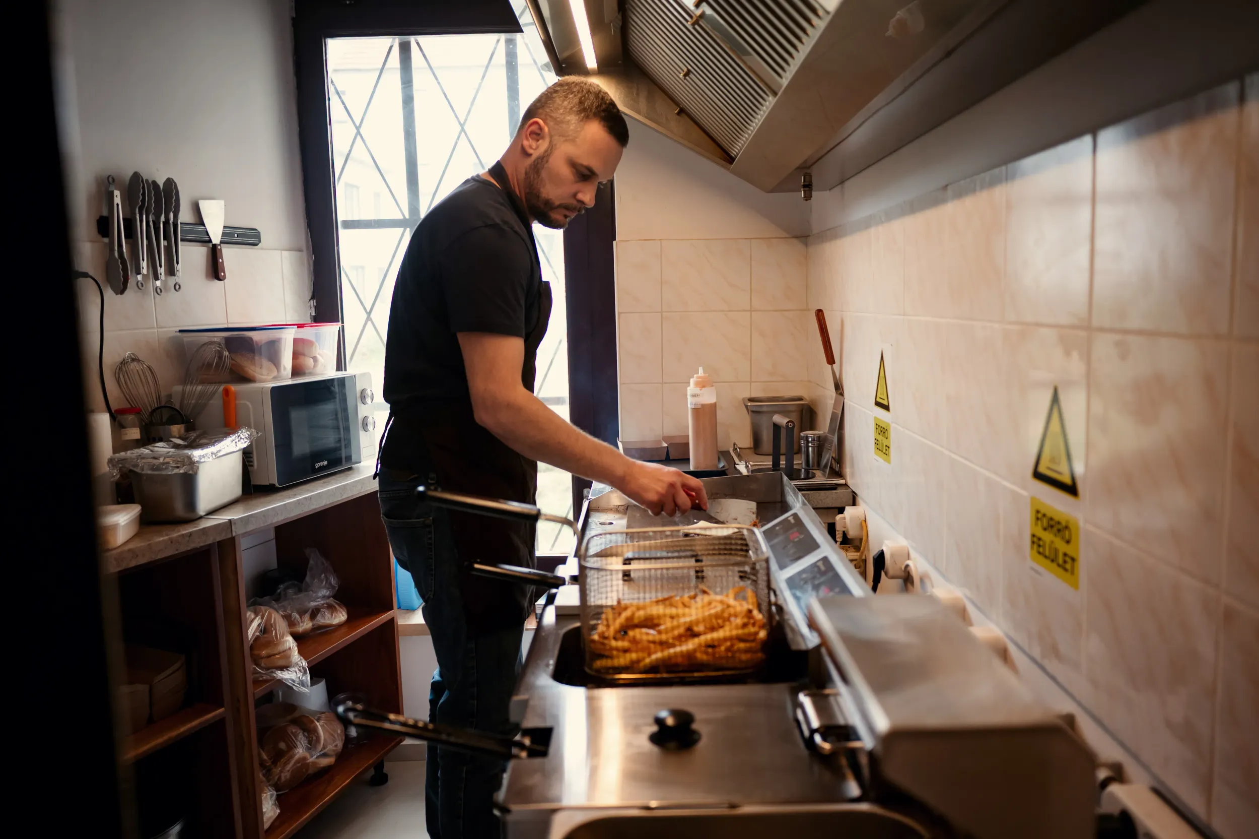 Készülnek a hamburgerek és a krumplik a Holy Fries konyháján