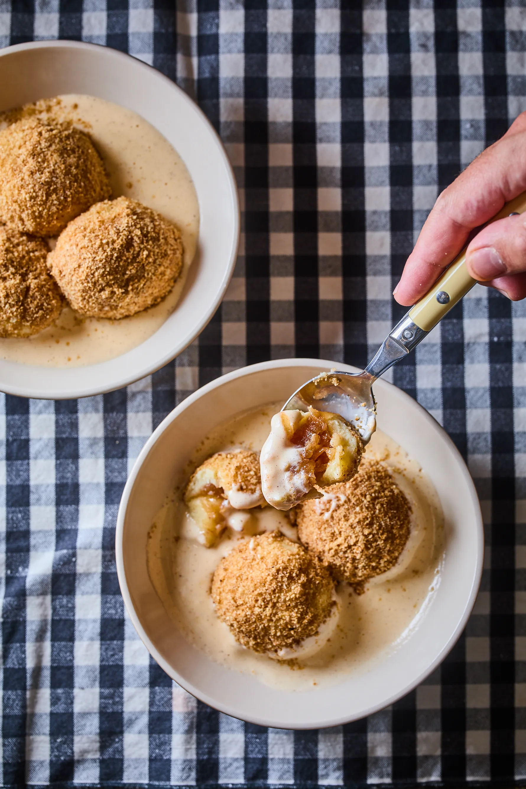 Almás gombóc vaníliasodóval tányérban, kanállal