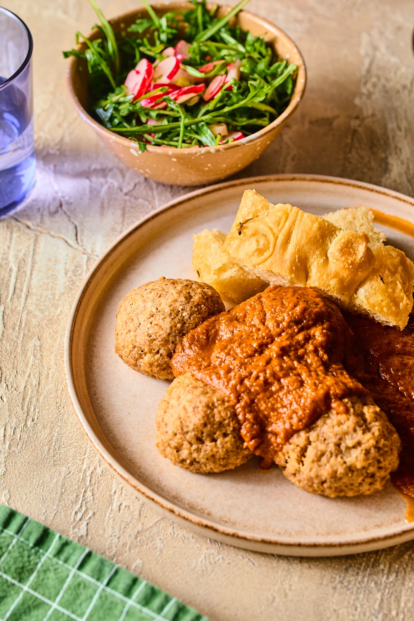 Diós rizsgolyó paradicsomszószban focacciával és rukkolasalátával