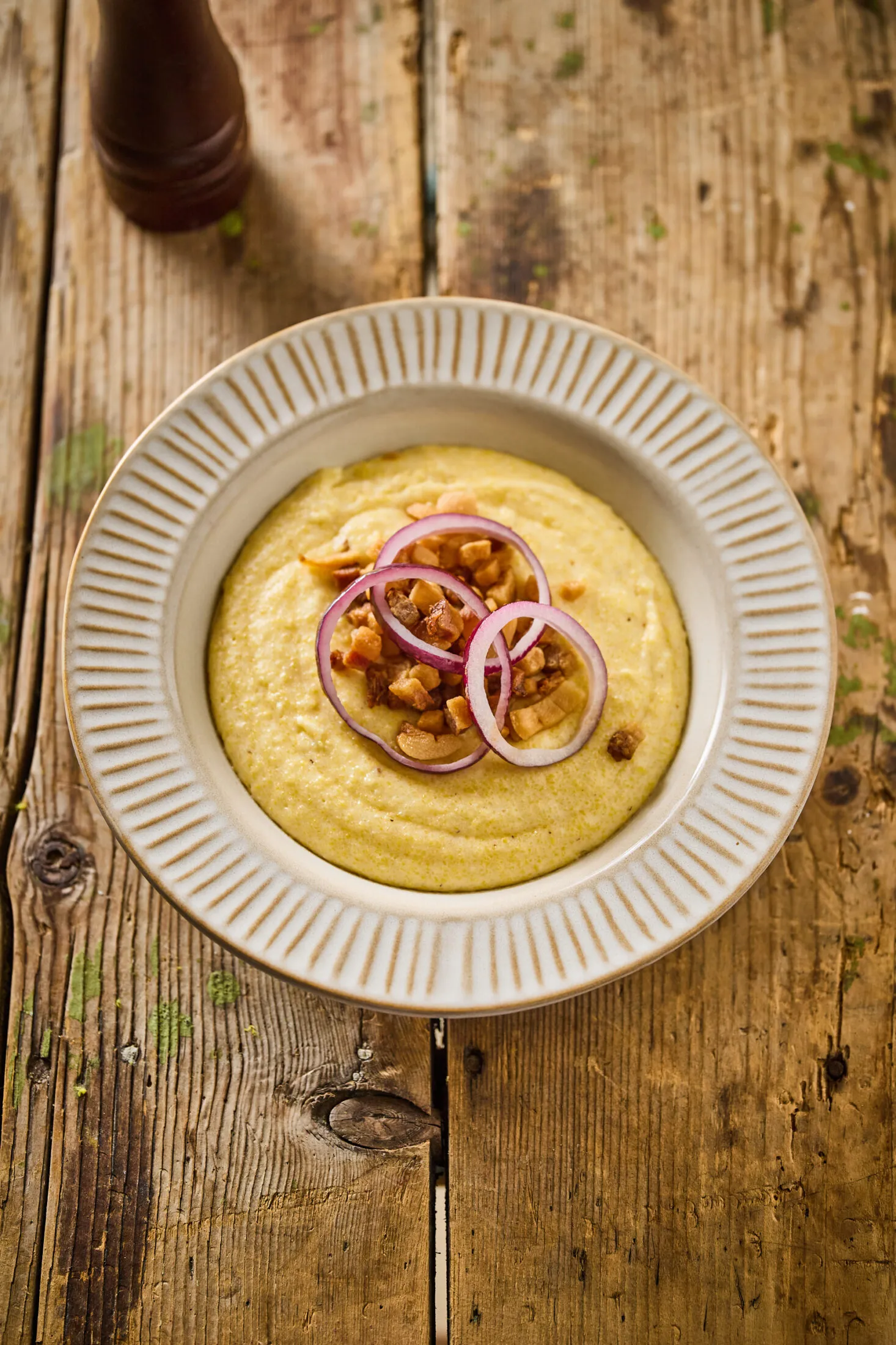 Puliszka szalonnával, lila hagymával tányéron