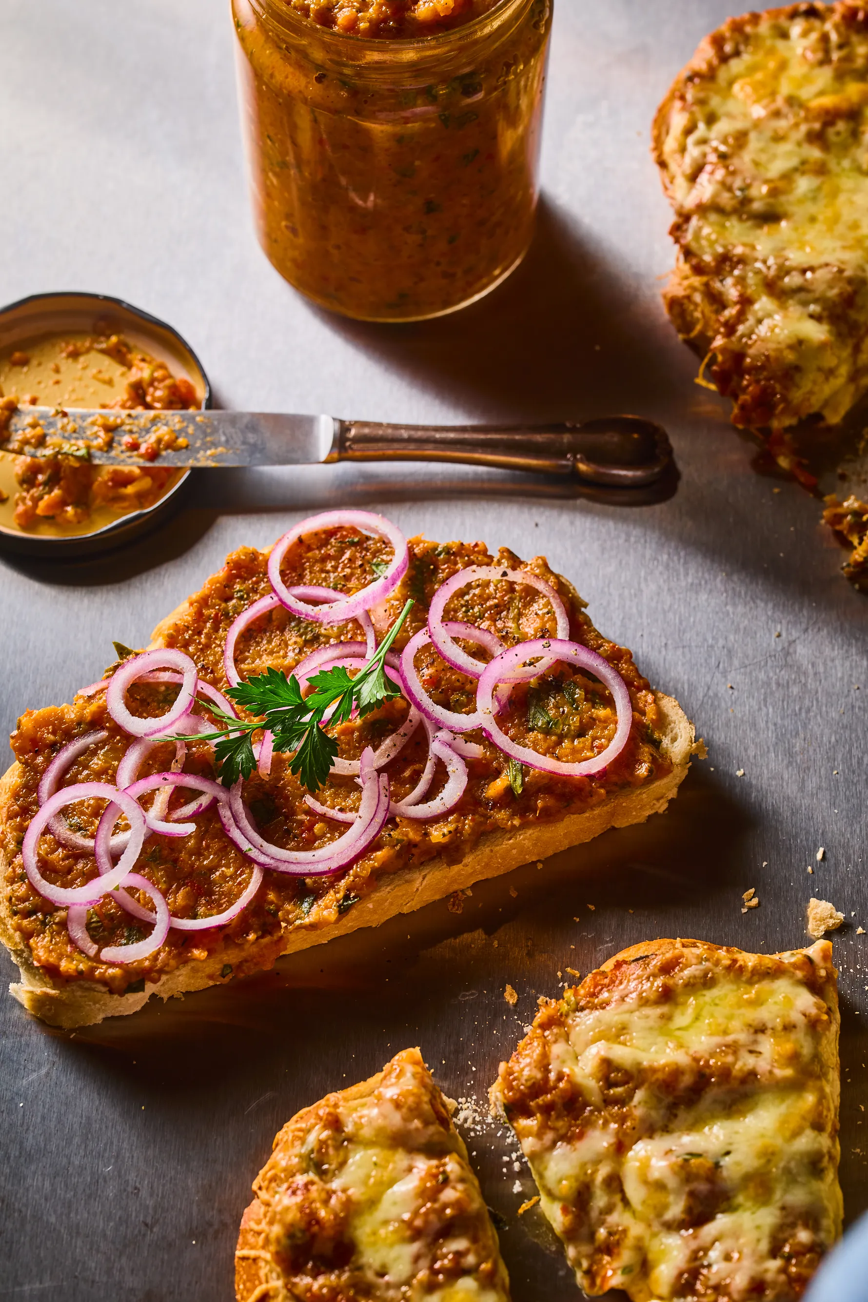 Szendvicskrém sült zöldségekből kenyérre kenve lila hagymával