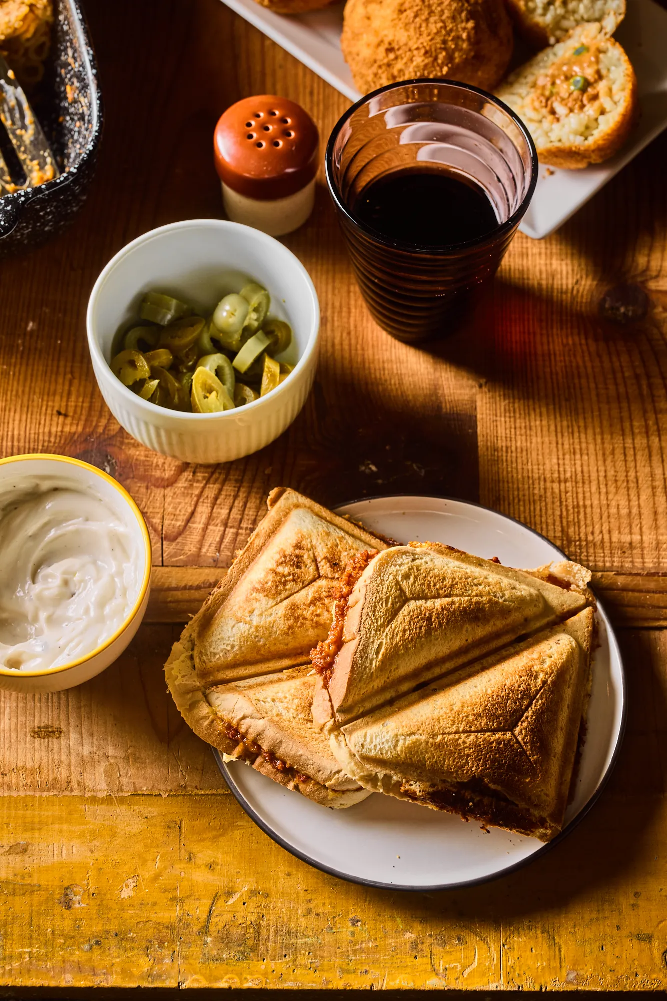 Vegán raguval töltött melegszendvics tányéron, jalapenoval, bazsalikomos majonézzel