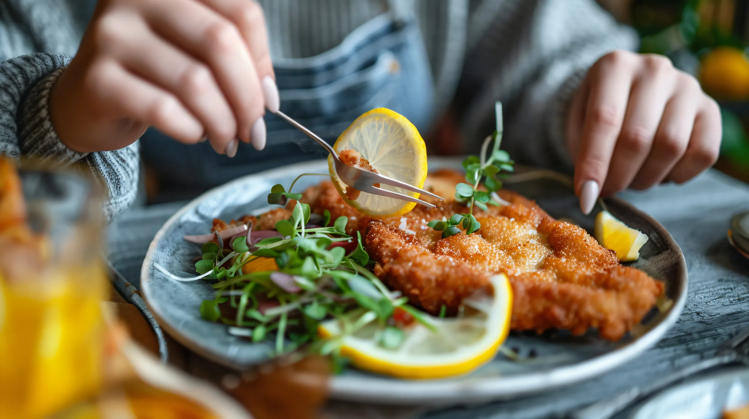 woman-eating-delicious-schnitzel-with-lemon-microgr