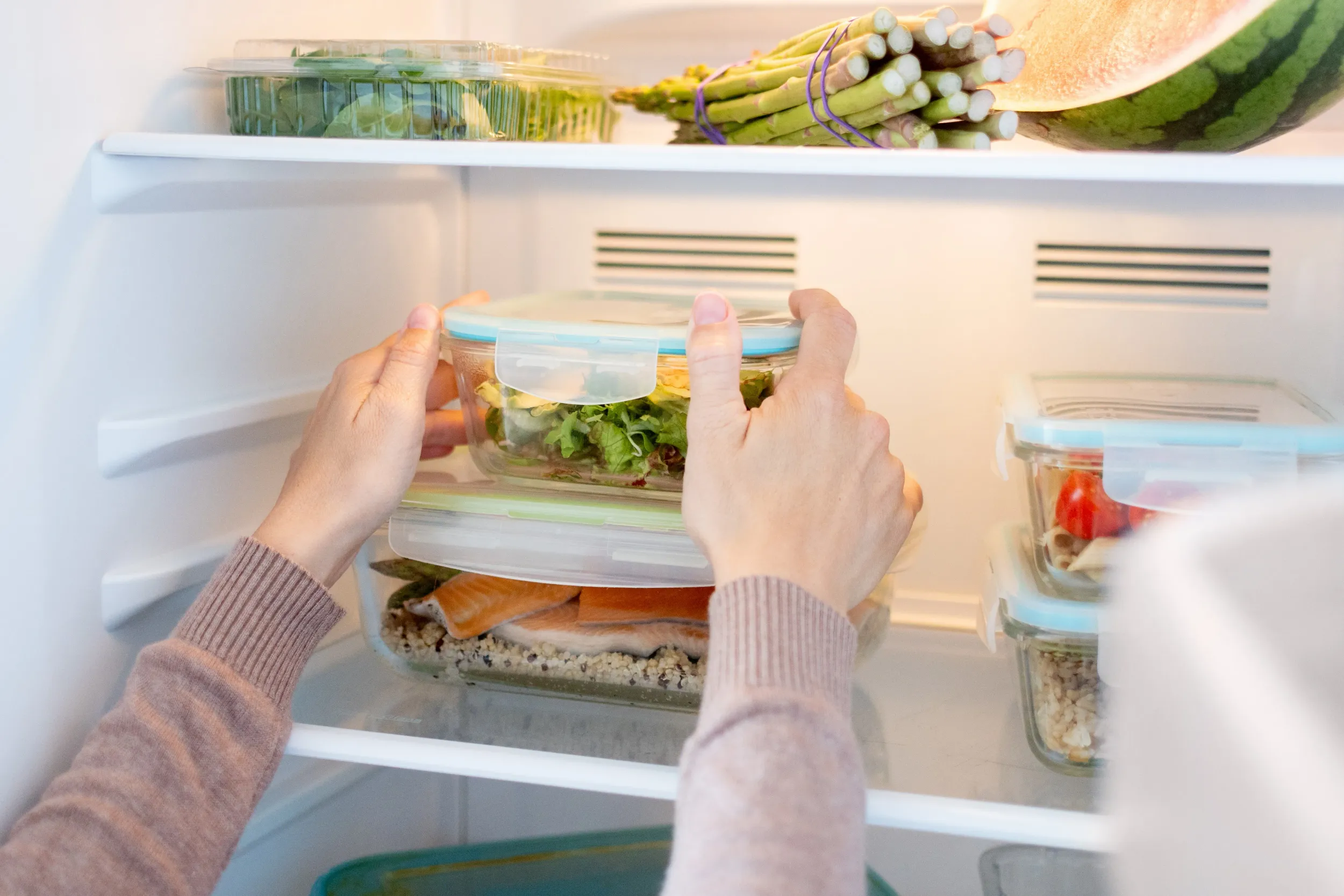 woman-organizing-healthy-meal-prep-containers-refrigerator-home