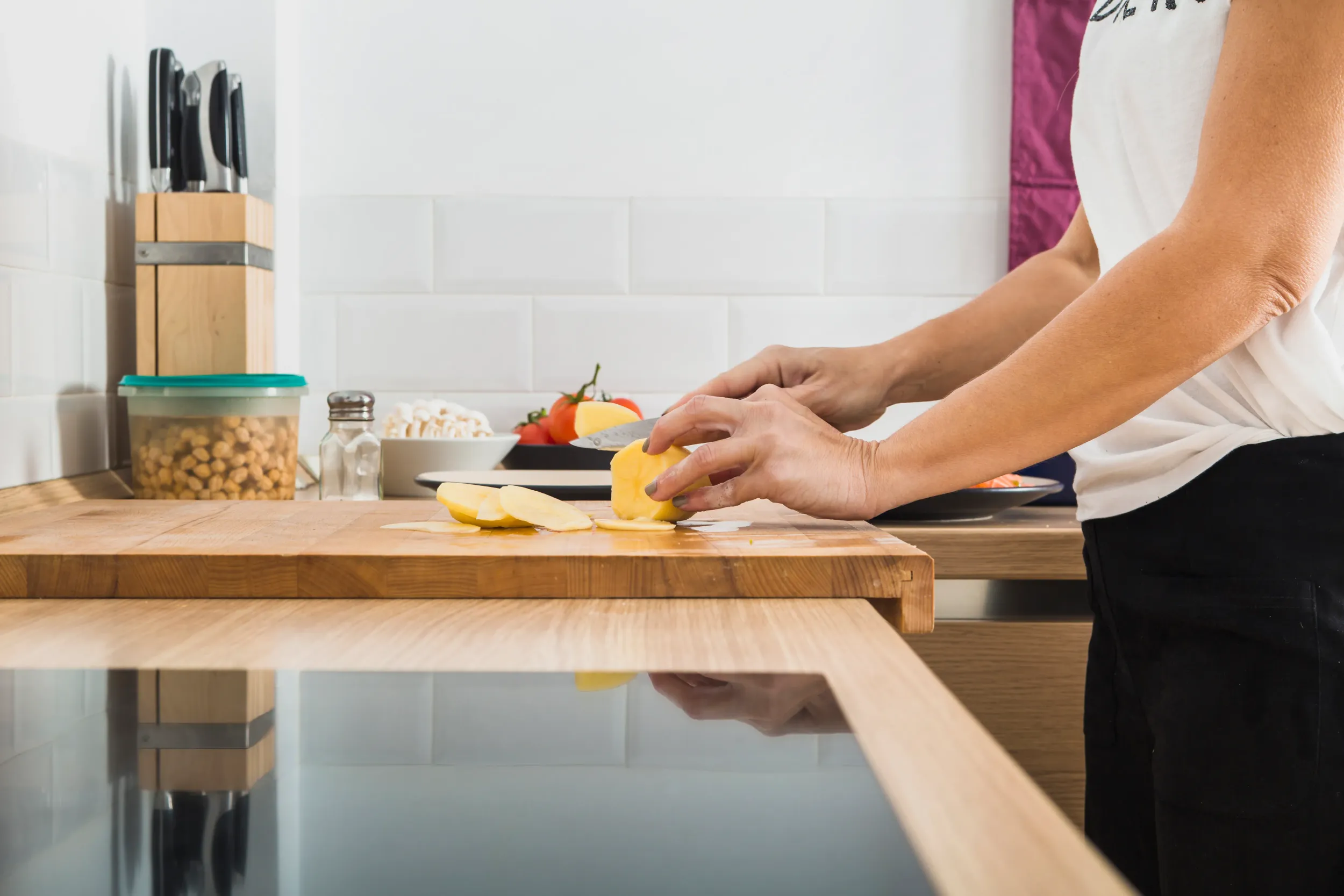 woman-standing-kitchen-cutting-potatoes