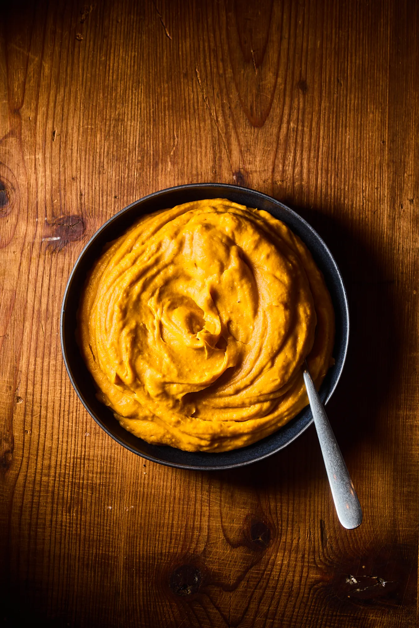 Zöldséges édesburgonyapüré tányérban, kanállal